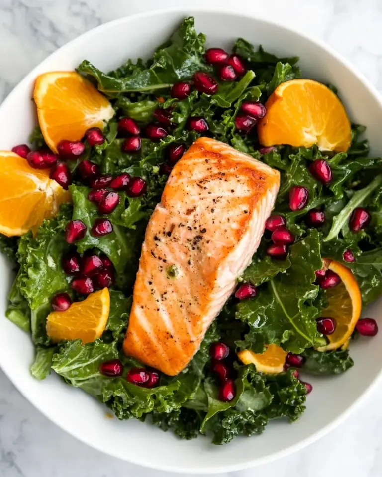 Delicious Kale Salad Recipe With Salmon, Pomegranate, And Orange-Coconut Vinaigrette food shot