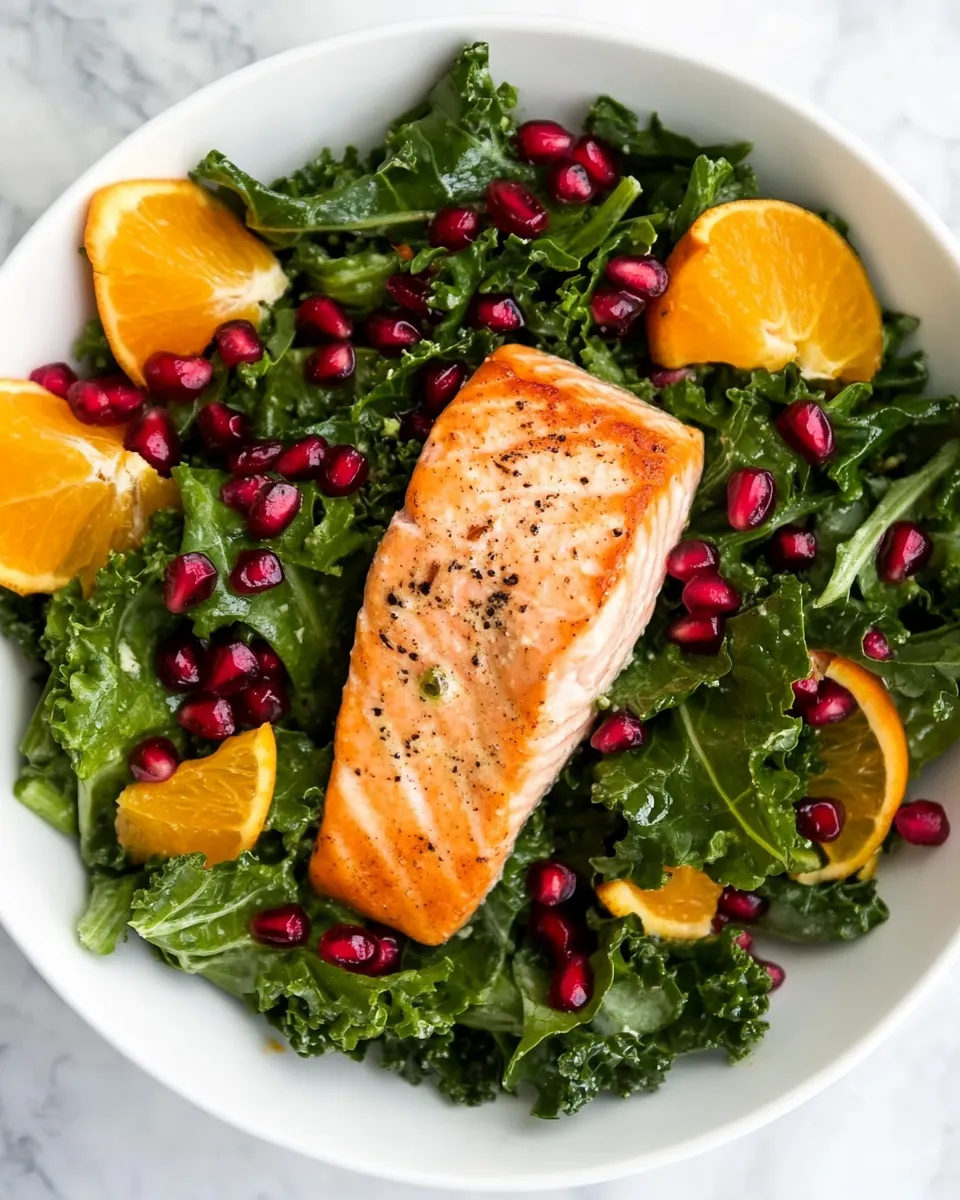 Delicious Kale Salad Recipe With Salmon, Pomegranate, And Orange-Coconut Vinaigrette food shot