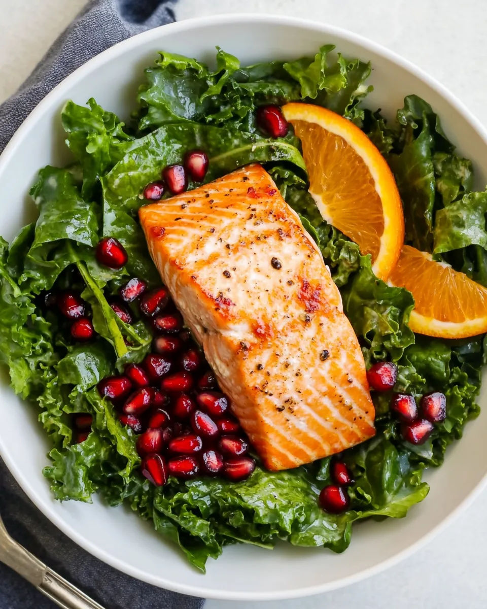 Fresh Kale Salad Recipe With Salmon, Pomegranate, And Orange-Coconut Vinaigrette plate image